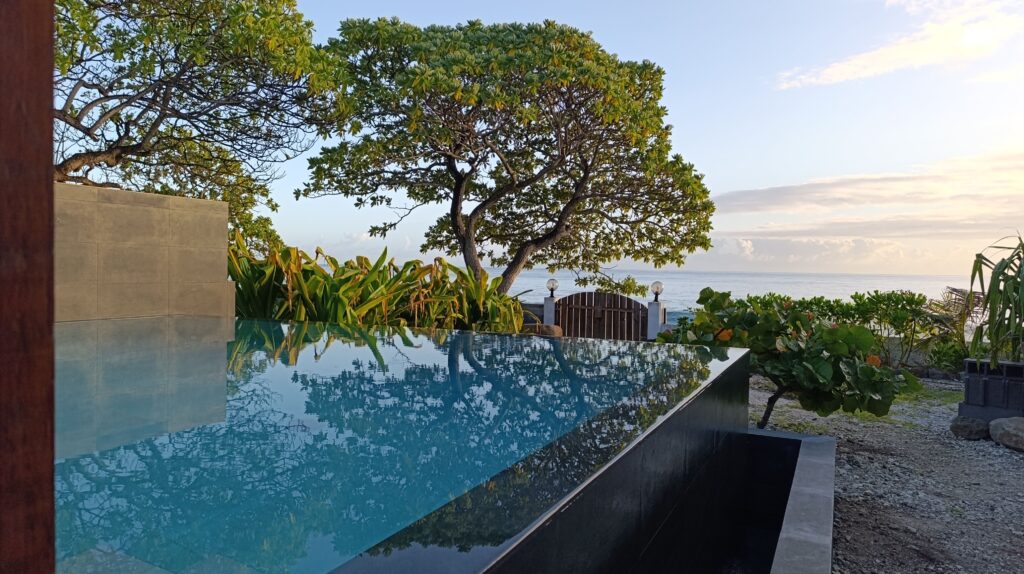 Private infinity pool overlooking the Pacific Ocean at Moorea Ocean Love, surrounded by a peaceful seaside garden.